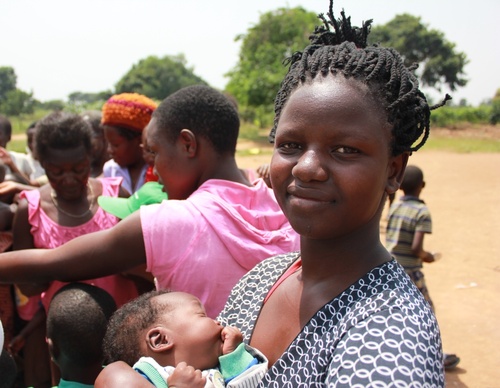 Mutter mit Säugling in Schlage Eine Mutter steht mit ihrem Säugling in einer Schlange in Nkumba, dem Zielort des Ugandahilfeprojektes.